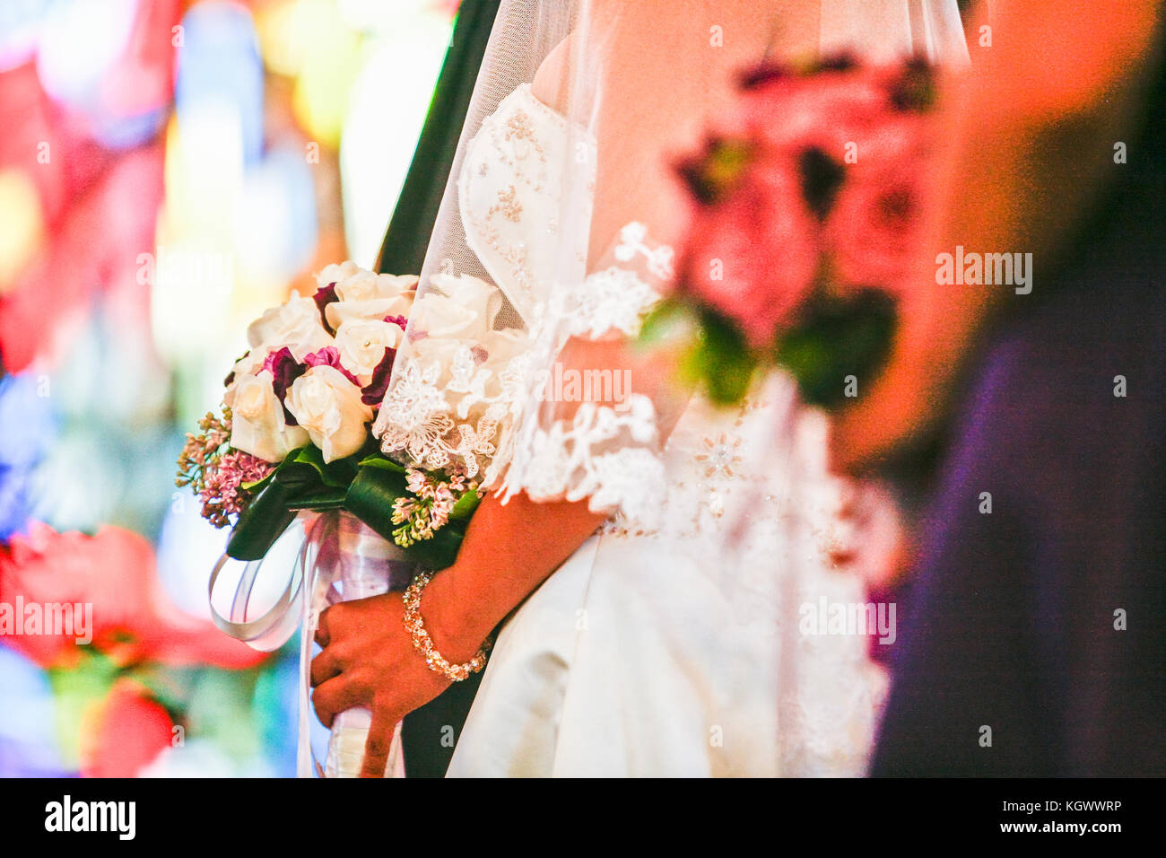 Cerrar y vista lateral de la novia tiene ramillete en ceremonia de boda Foto de stock