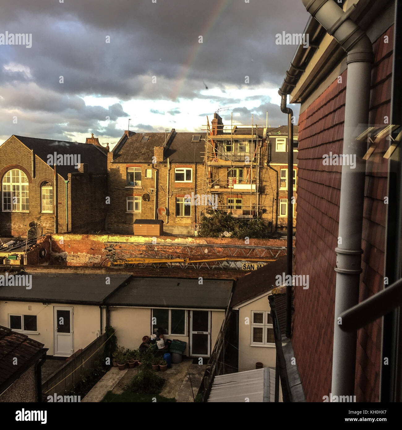 Un arco iris que dispara a través de una casa adosada sky line, al norte de Londres, Inglaterra, Reino Unido. Foto de stock