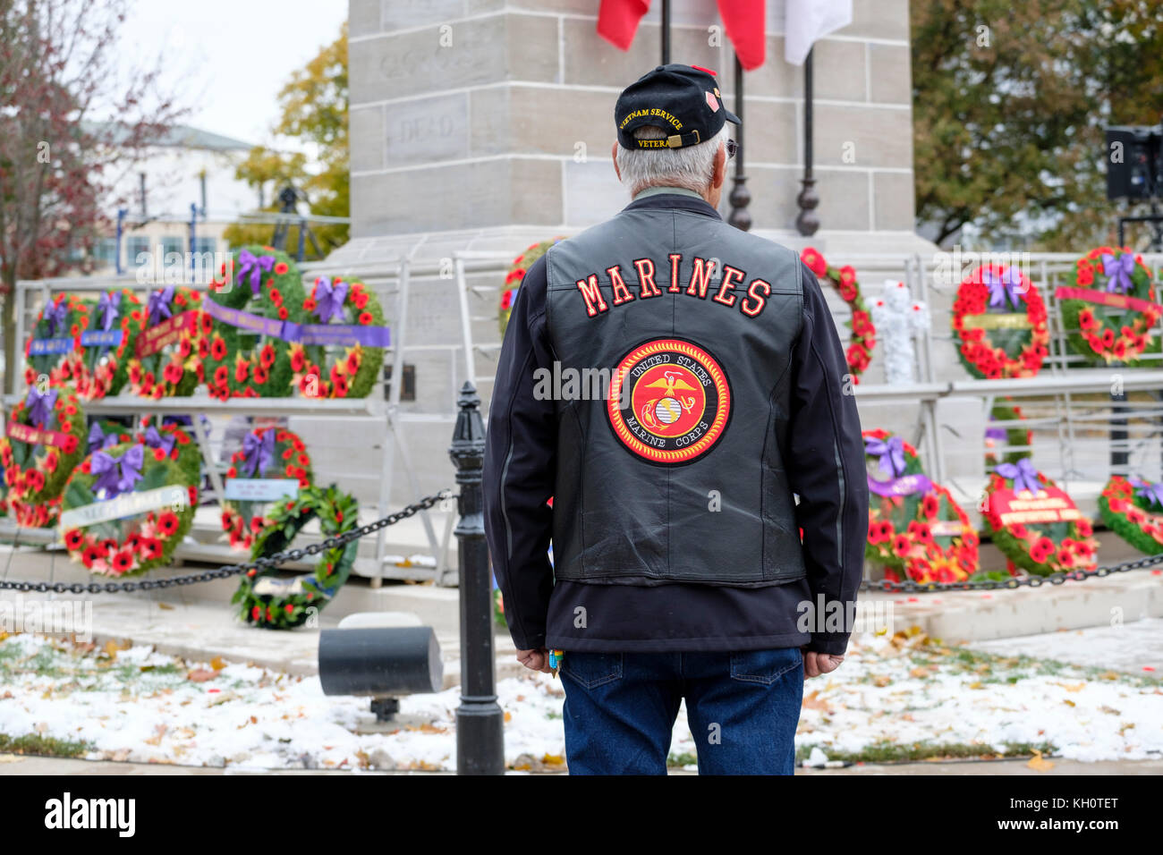 Native American/First Nations anciano veterano de la guerra de Vietnam mirando la amapola ofrendas florales en el cenotafio de Londres, Remembrance Day, London, Ontario, Canadá Foto de stock