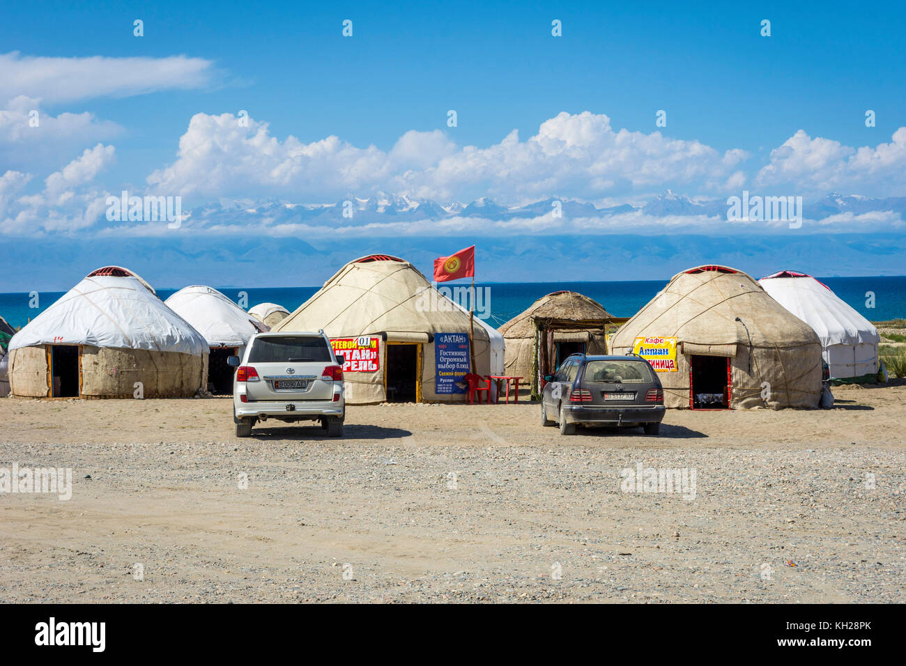 KYZYL TAMBIÉN, KIRGUISTÁN - 8 DE AGOSTO: Yurts junto al lago Karakol con la publicidad para los proveedores de datos móviles locales. Agosto de 2016 Foto de stock