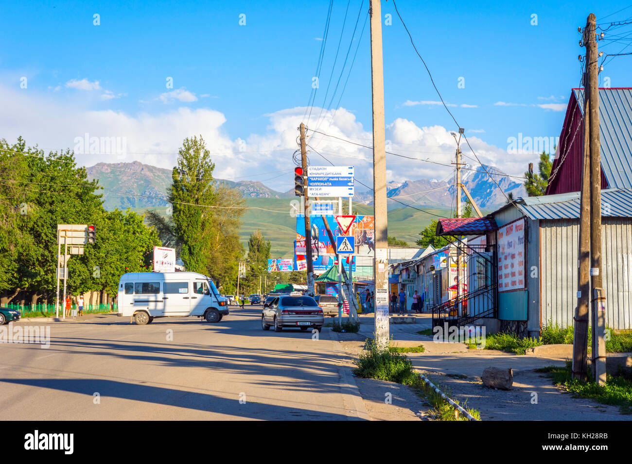 KARAKOL, KIRGUISTÁN - 2 DE AGOSTO: Vista sobre la calle con coches y tiendas en la ciudad de Karakol. Agosto de 2016 Foto de stock