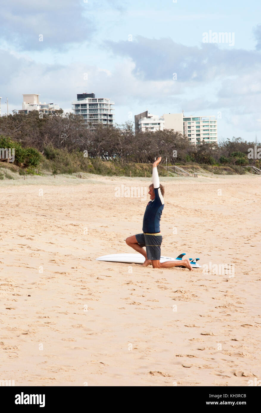 El hombre realizar rutinas de yoga en la playa en Alexandra Headland, Sunshine Coast, Queensland, Australia Foto de stock