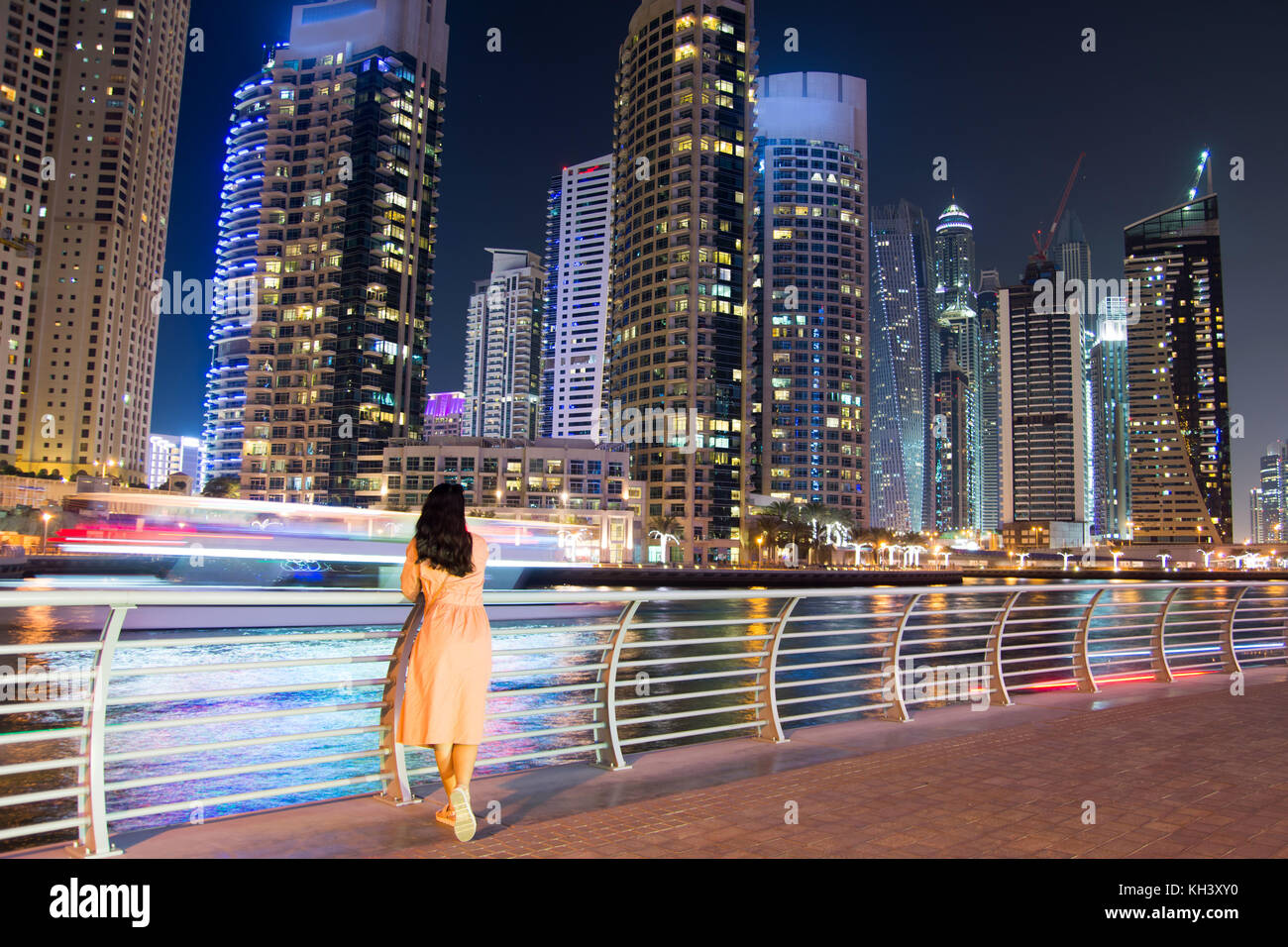 Chica disfrutando de Dubai Marina modernos rascacielos vista nocturna Foto de stock