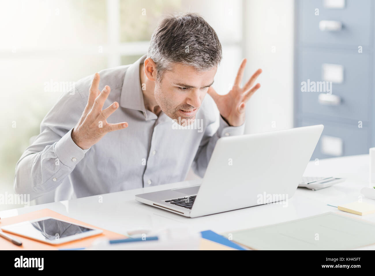Enojado frustrado trabajador de oficina tiene problemas con su ordenador portátil y conexión, problemas de concepto Foto de stock