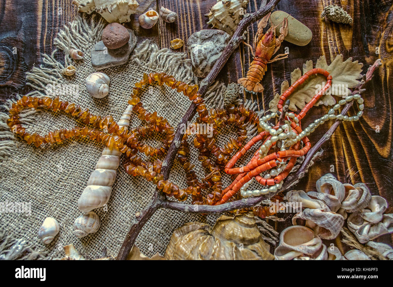 Antiguo río perlas de perlas, corales rojos con perlas de ámbar en bruto  sobre lienzo con conchas y guijarros en placas oscuro Fotografía de stock -  Alamy