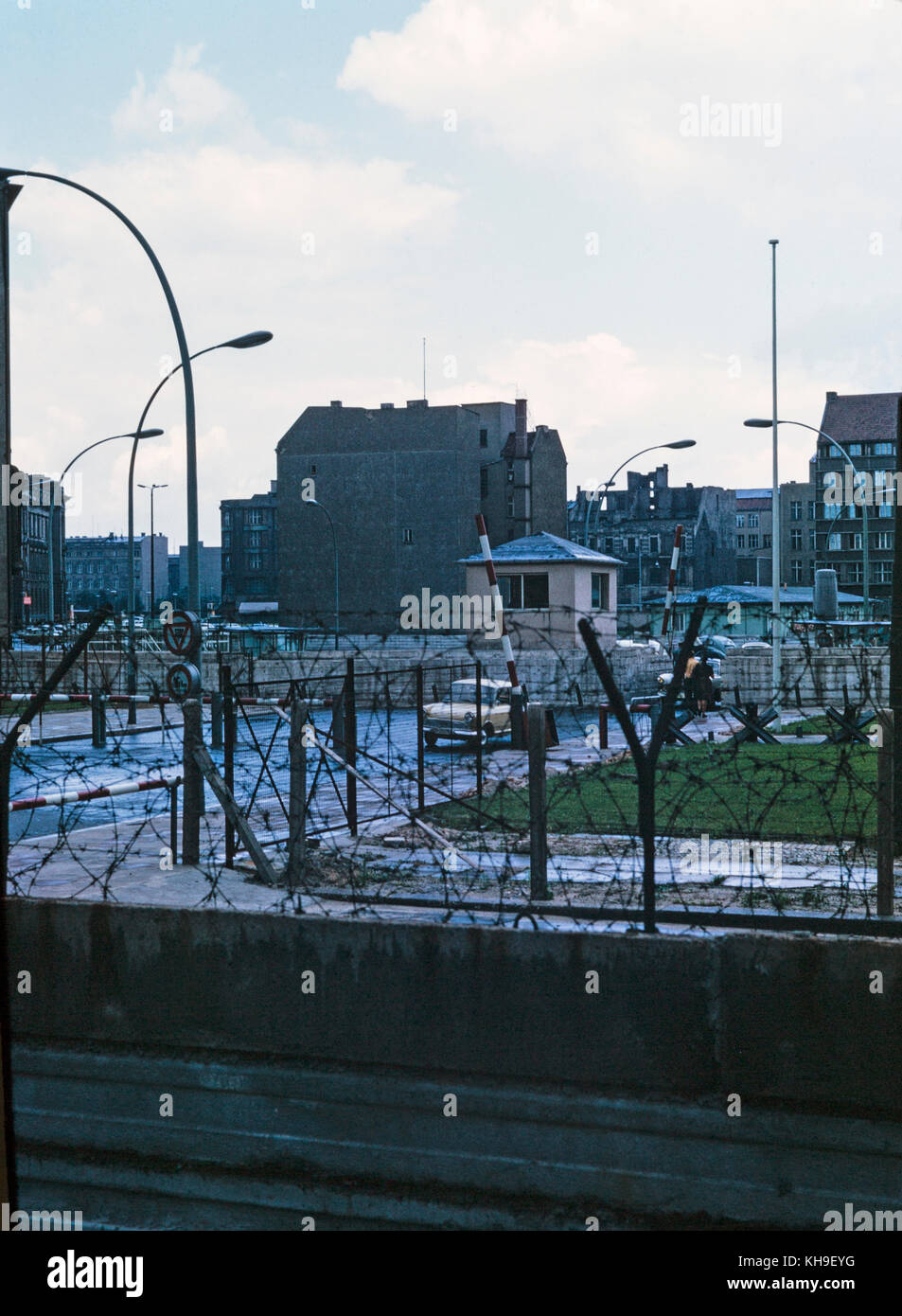 Foto tomada en agosto de 1965 mostrando la vista desde el lado alemán del oeste de Berlín, a través del Muro de Berlín, a la parte oriental de Berlín en Alemania Oriental. La foto muestra la pared cubierta con alambre de púas y una sala de guardia militar. Foto de stock