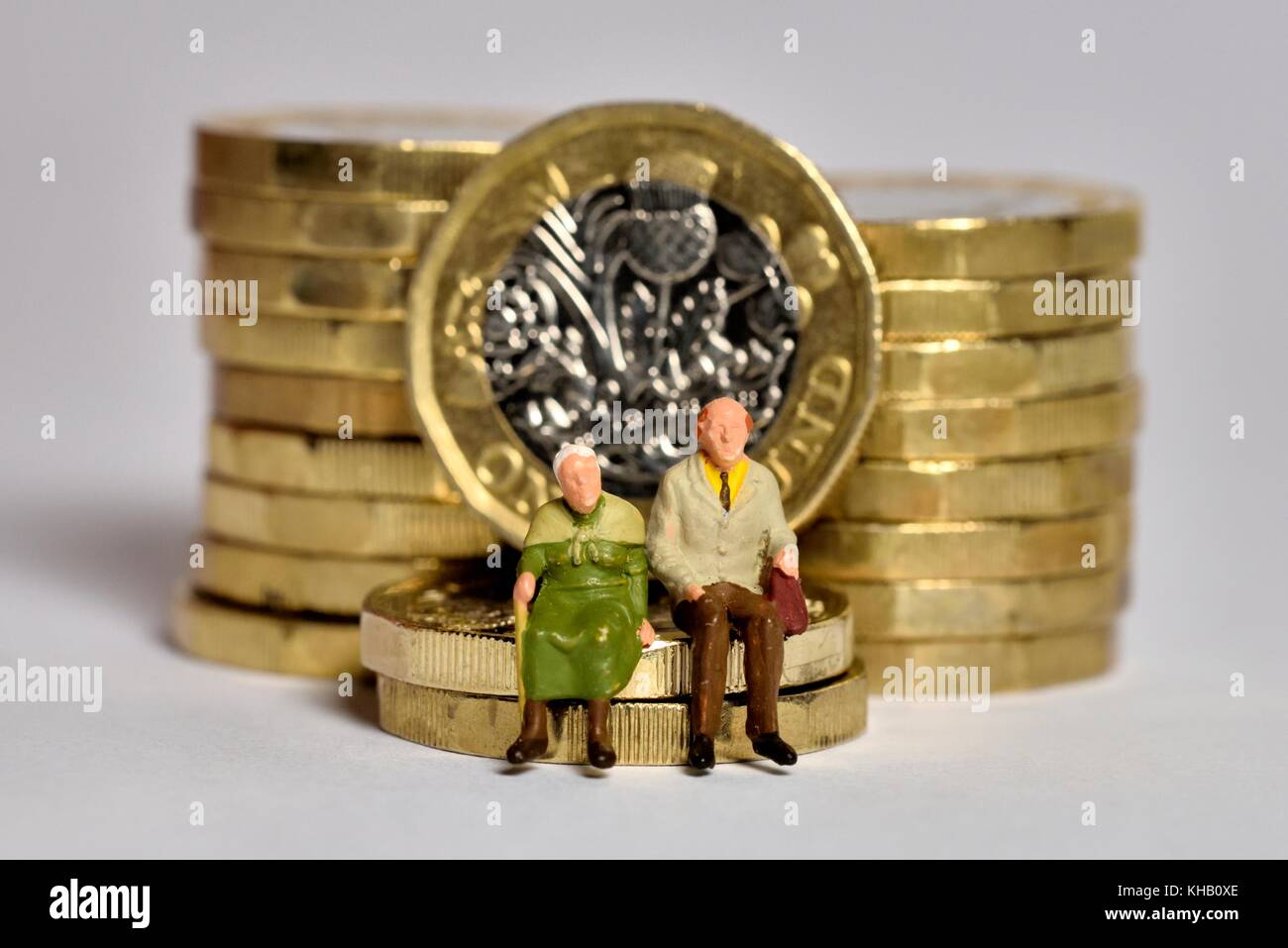 Los pensionistas sentados en British Pound monedas Foto de stock