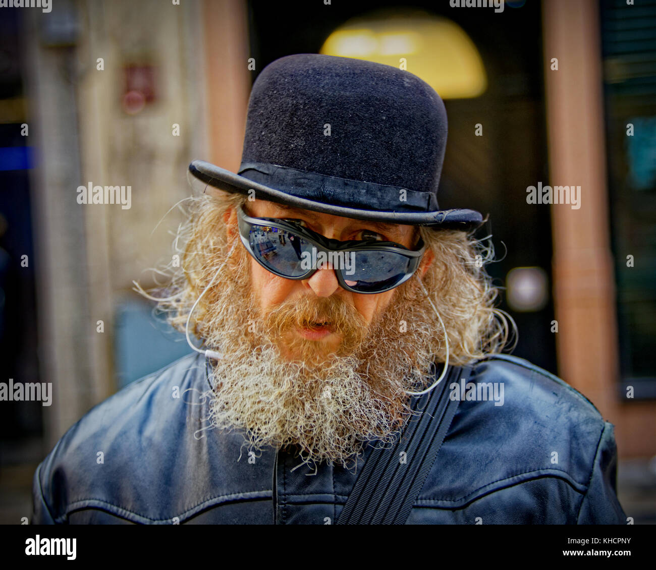 El artista local frankie Patrick Robertson, personaje en la calle sombrero impermeable gafas de sol hombre feliz barbudo conectado al sonido Foto de stock