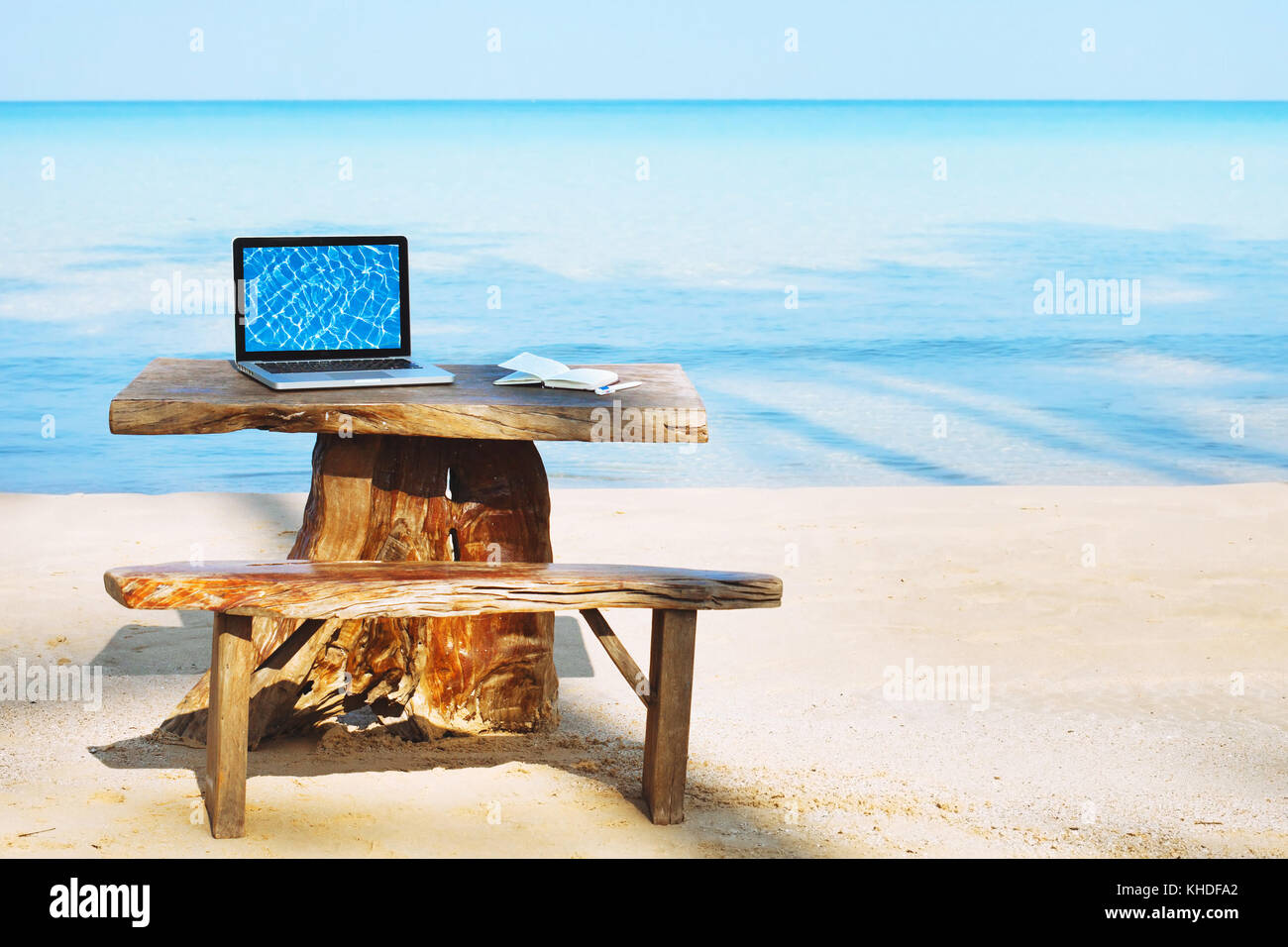 Oficina de freelancer en la playa, ordenador portátil con pantalla vacía y nadie, concepto freelance Foto de stock