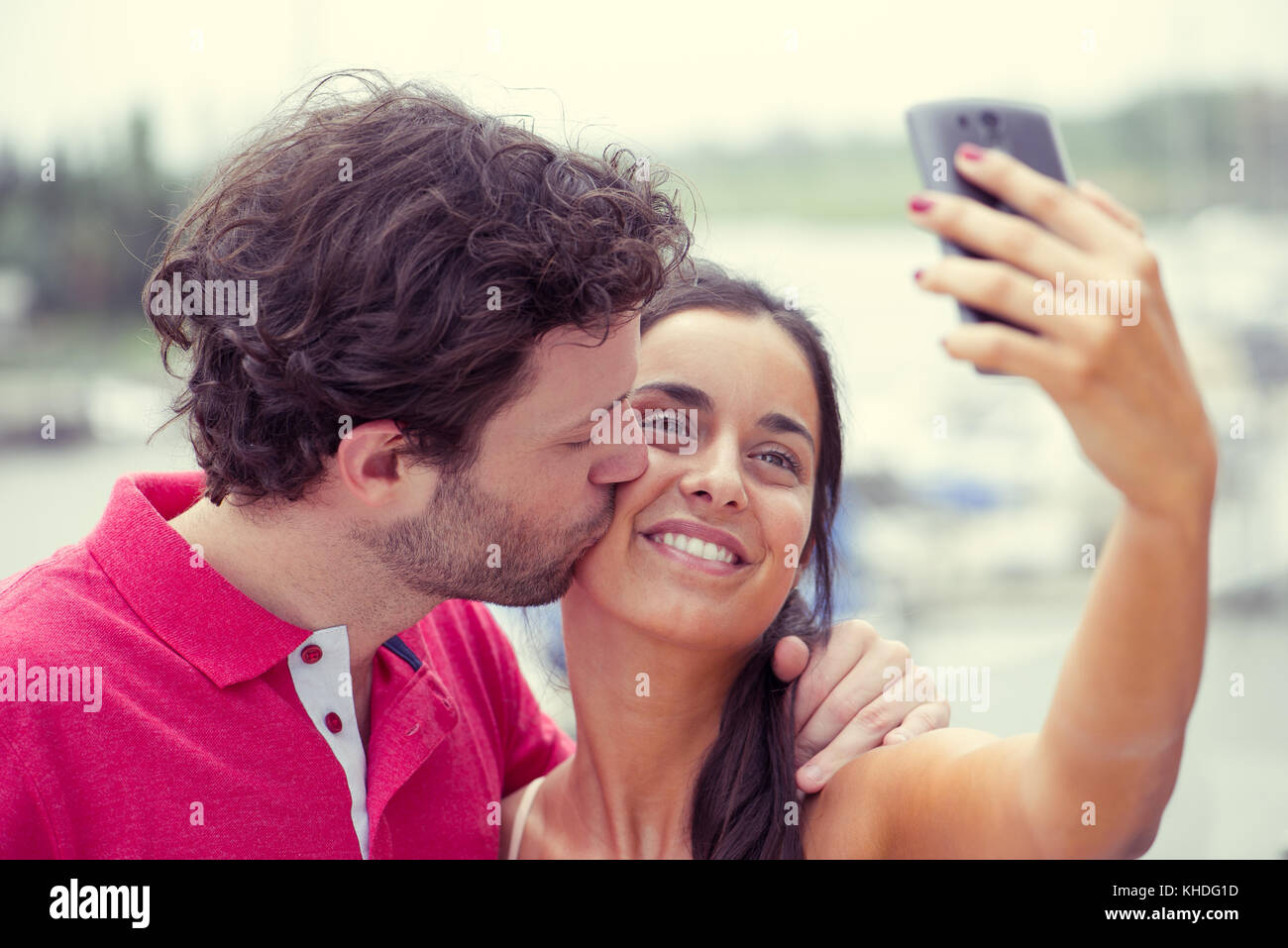 Hombre y mujer posando para selfie tomadas con teléfonos inteligentes. Foto de stock