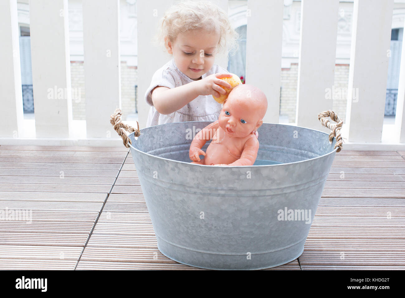 Niña bañándose baby doll en la cuchara al aire libre Fotografía de stock -  Alamy