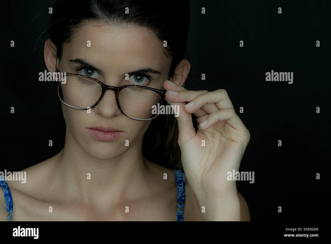 Mujer joven mirando por encima de sus gafas, Retrato Foto de stock