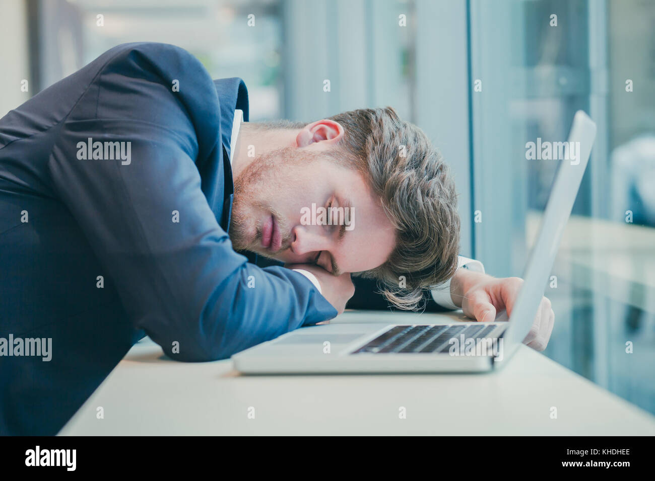 Empresario cansado durmiendo cerca de un ordenador Foto de stock