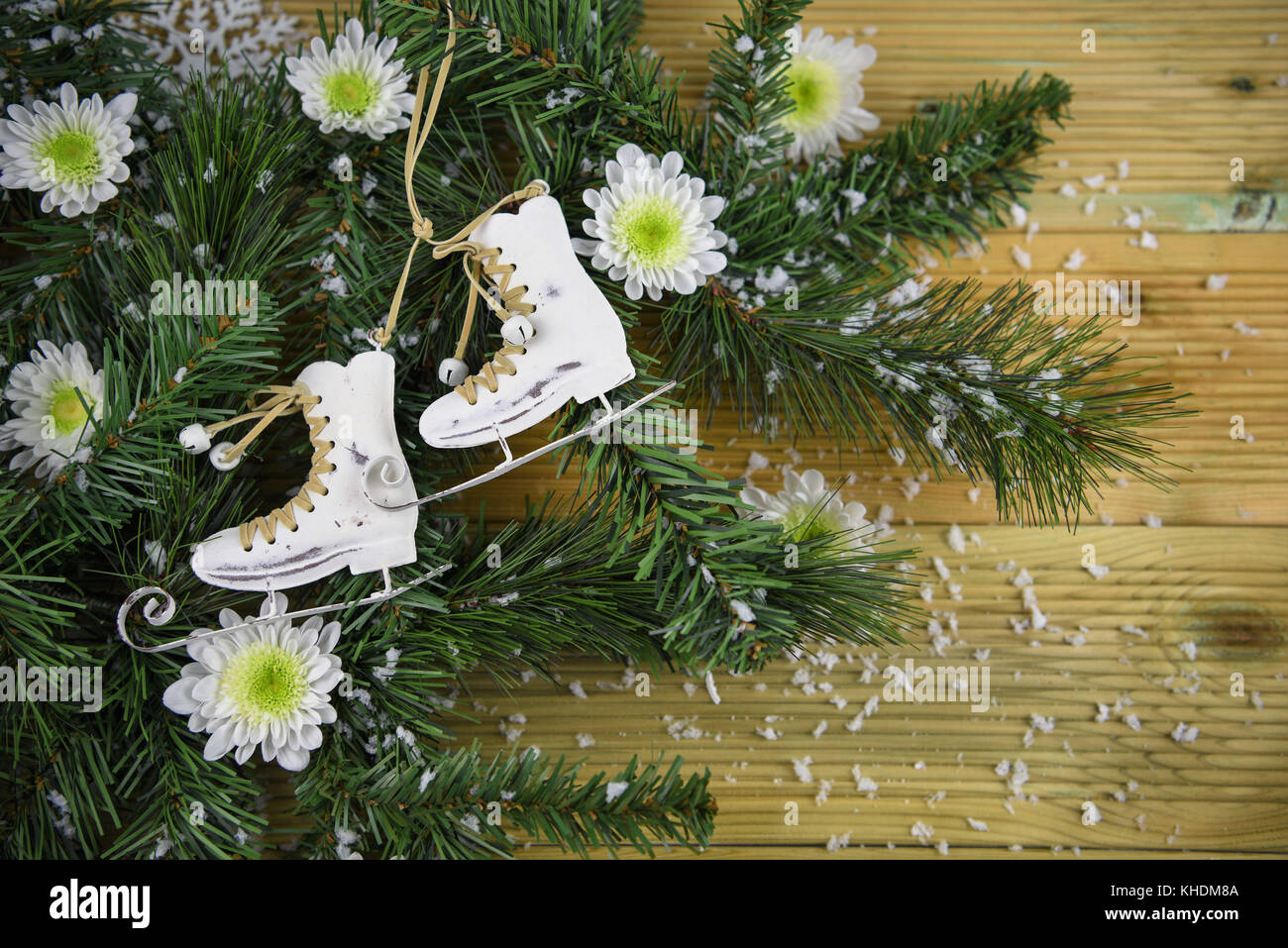 Fotografía de navidad en el color verde de las ramas de un árbol de navidad con flores de invierno blancos frescos y copos de nieve con árbol decoración de patinaje sobre hielo boot Foto de stock