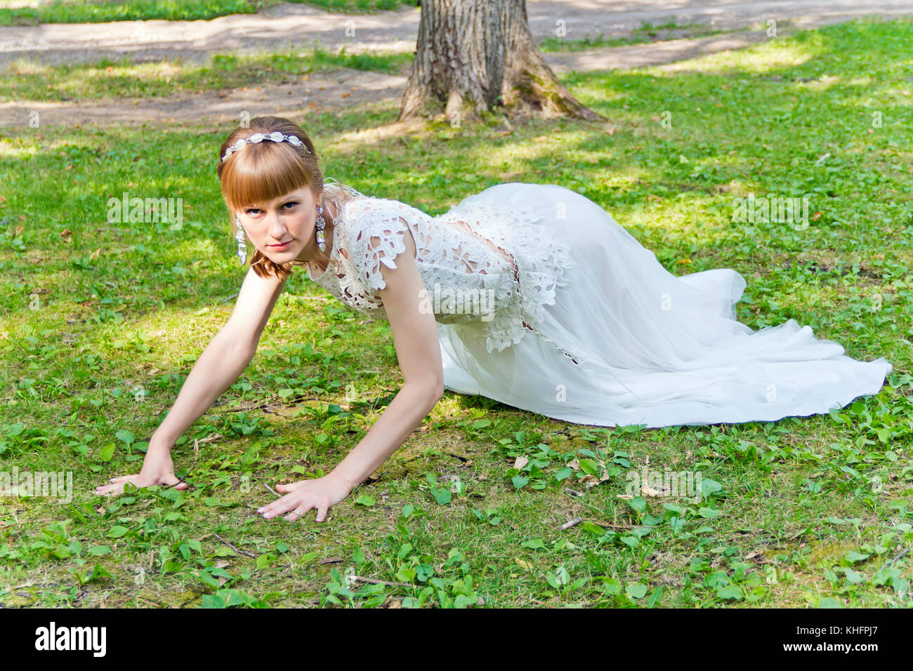 Novia Vestido encaje blanco arrastrarse sobre el pasto verde en el verano  Fotografía de stock - Alamy