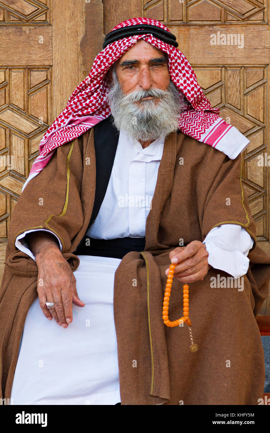 Barbudo anciano turco en los trajes locales con su rosario, en Sanliurfa, Turquía. Foto de stock