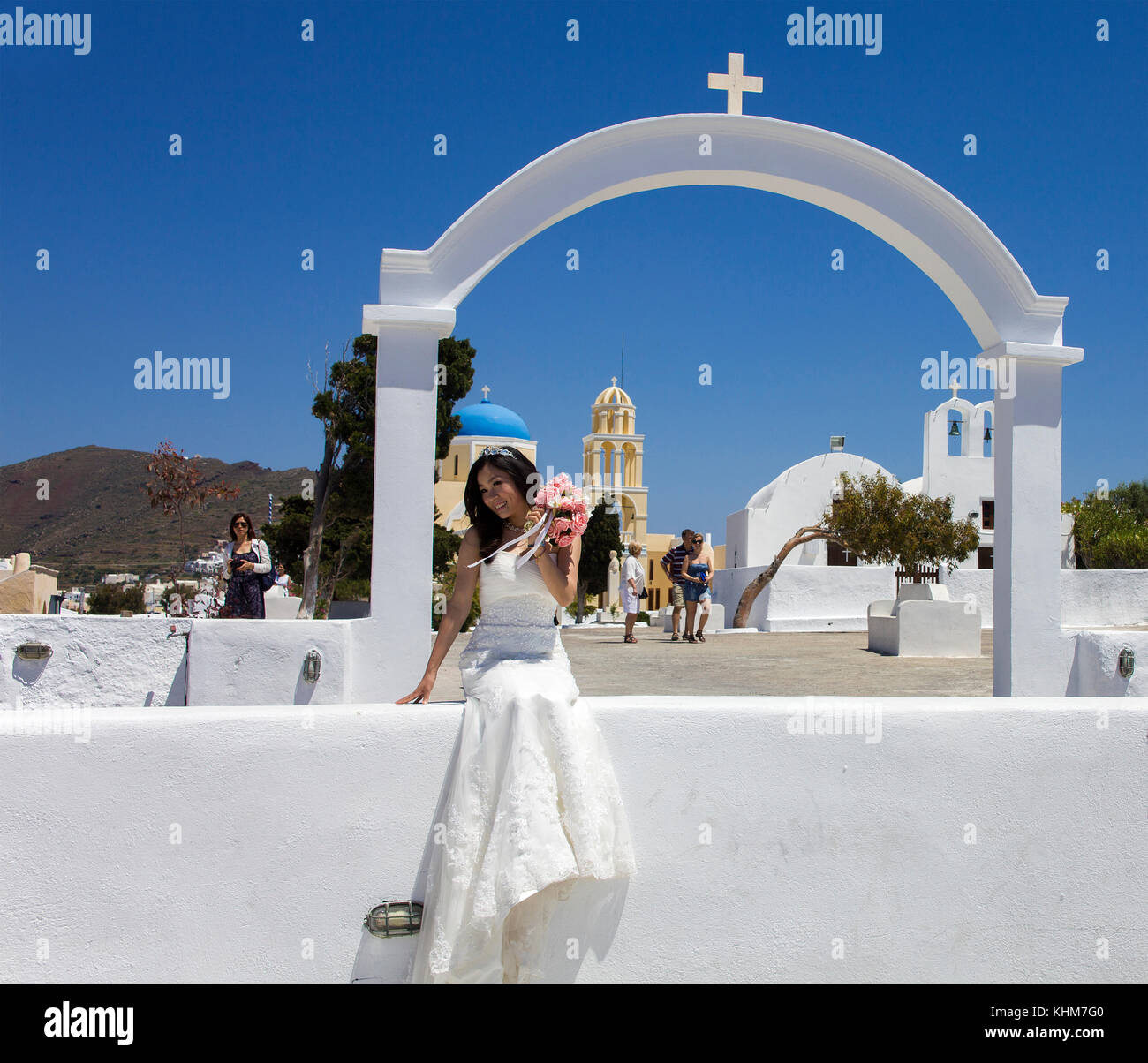 Con el ramo de novia posando en Oia, la iglesia ortodoxa, de la isla de Santorin, cyclades, Egeo, Grecia Foto de stock