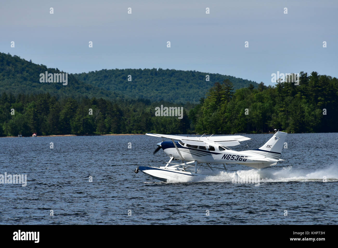 2004 Stationair Cessna Turbo motor único avión de ala fija con pontones despegando desde el lago Pleasant, NY. Foto de stock