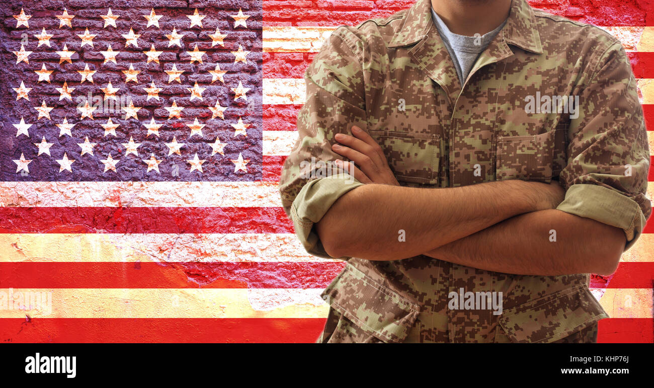 Soldado en un patrón digital uniforme militar estadounidense, de pie sobre  un fondo de la bandera americana Fotografía de stock - Alamy