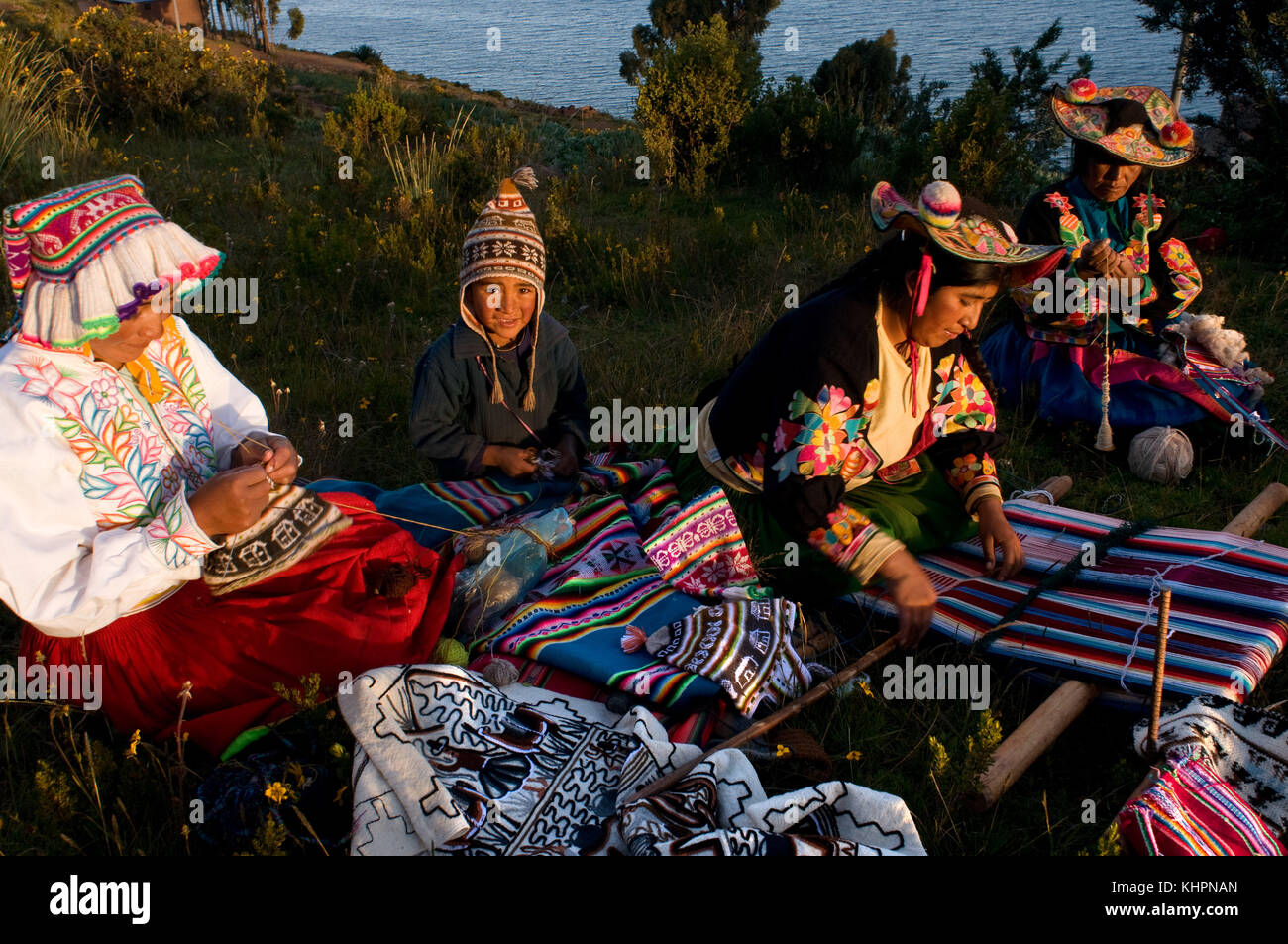 Pueblo de llachón, la península de Capachica, cerca de Puno, Perú. Varias mujeres en llachón comprometidas en el trabajo de tejer la colorida ropa con la que d Foto de stock