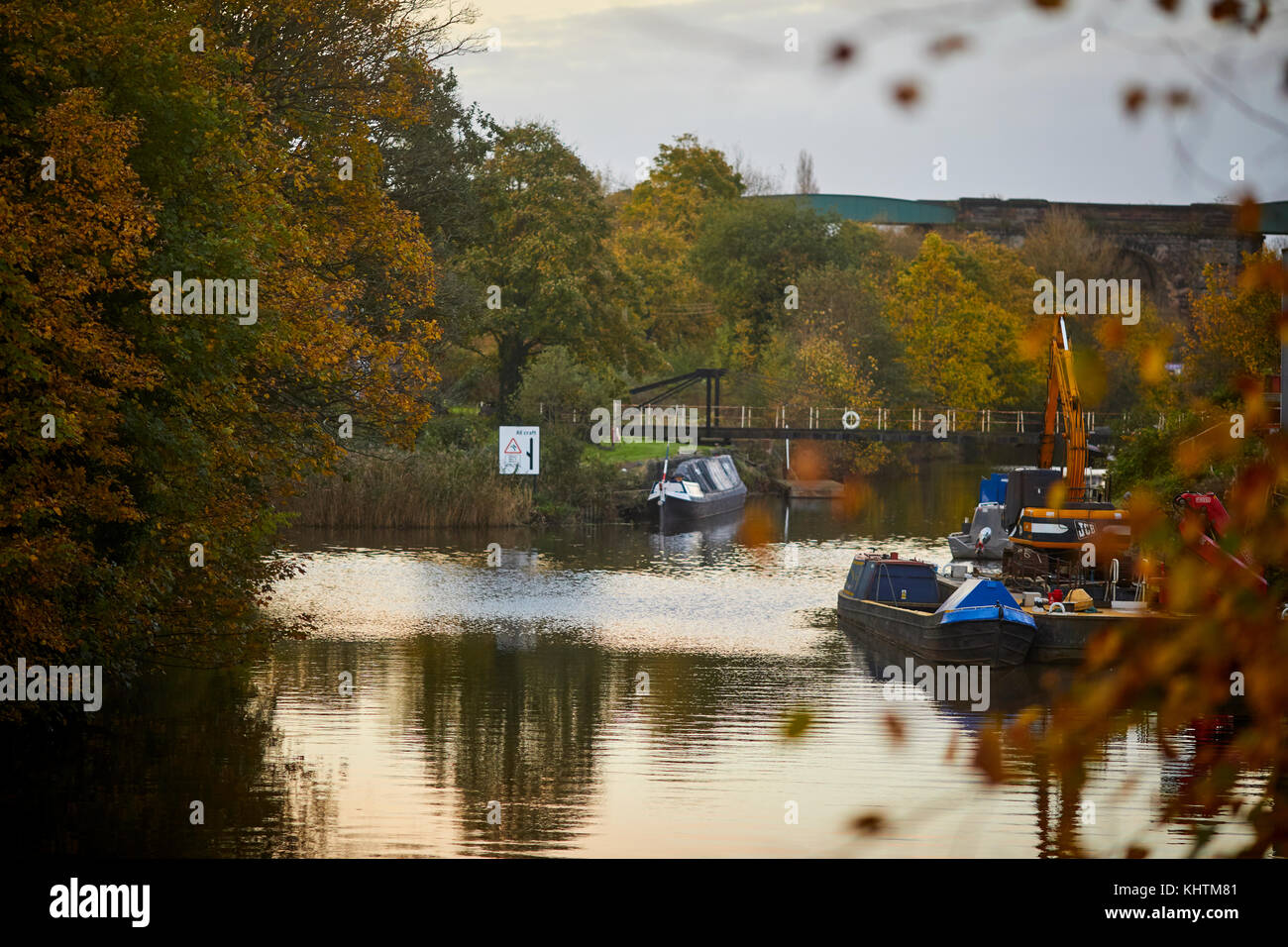 Canal embarcaciones flotando en el río Weaver con golden otoño los árboles en el paisaje, Northwich en Cheshire Foto de stock
