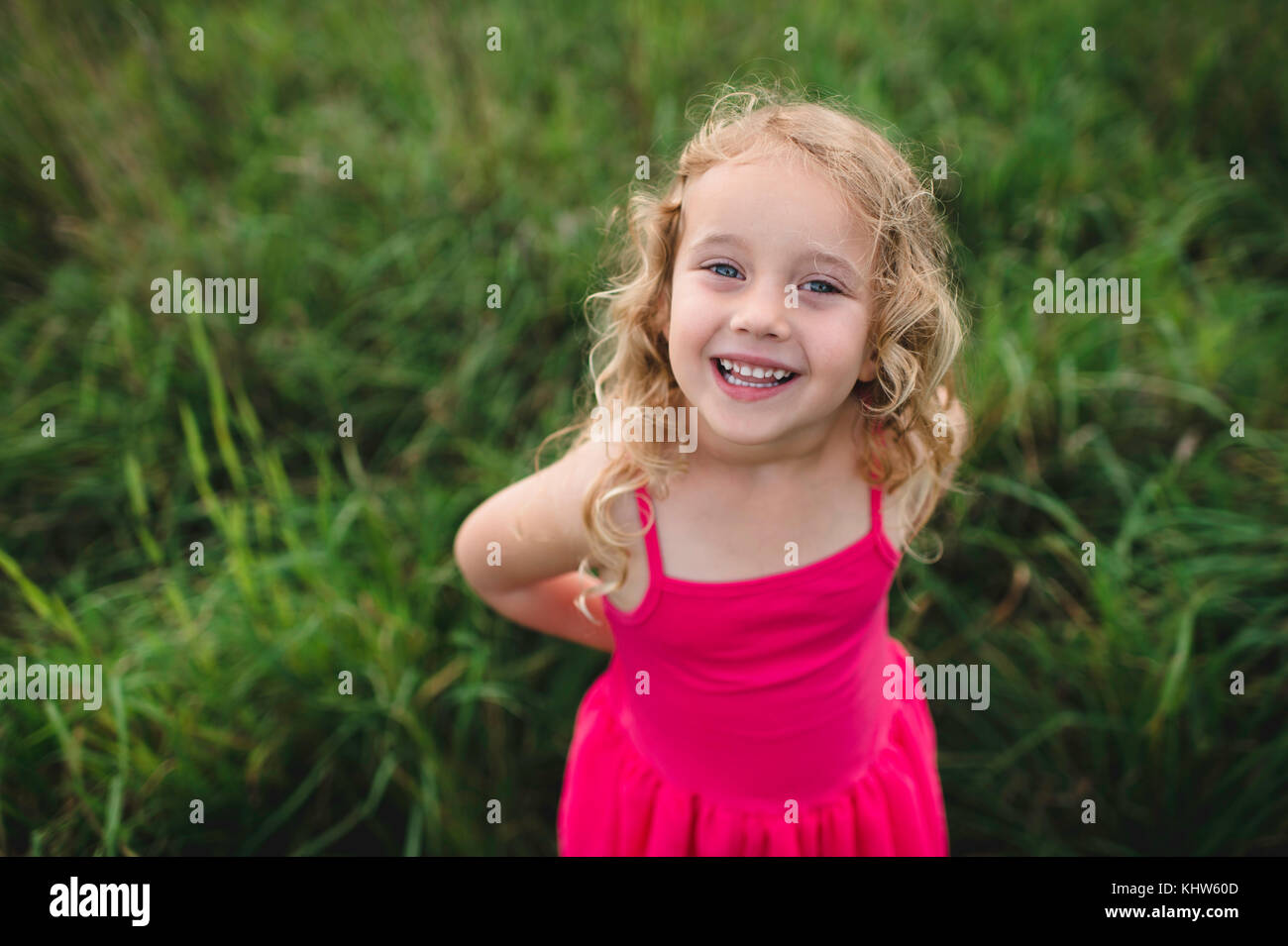 Retrato de la muchacha de los cabellos rubios en hierba Foto de stock