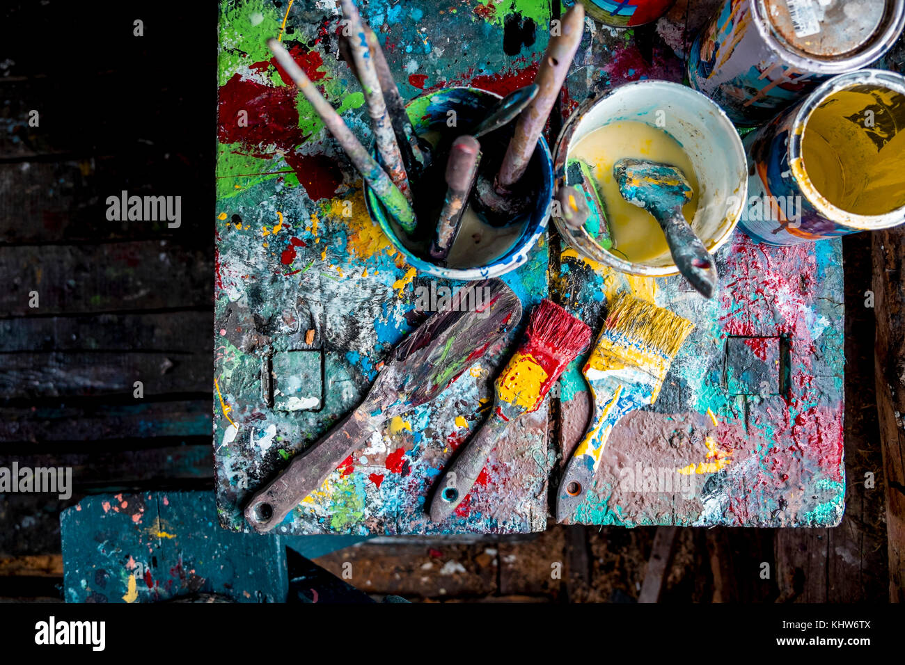 Pinceles y botes de pintura sobre tabla del taller Foto de stock