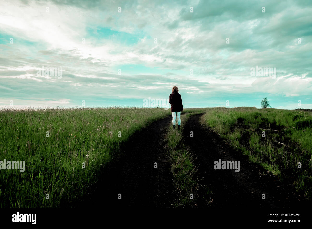 Mujer en la ruta a través del campo de hierba, Ural, Sverdlovsk, Rusia Foto de stock