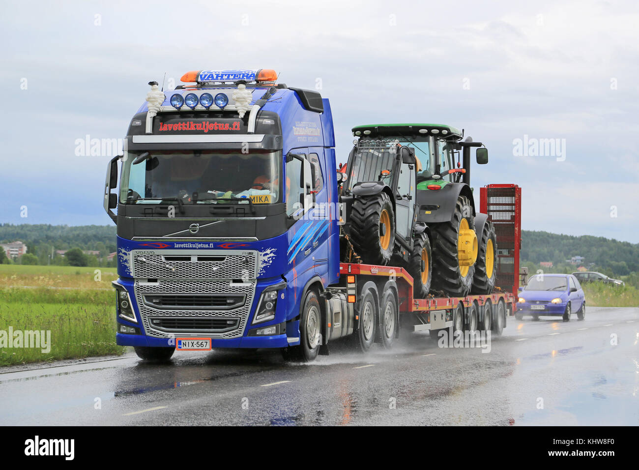 Salo, Finlandia - 10 de julio de 2015: Volvo FH16 lances sobre maquinaria John Deere remolque cuello de cisne. camiones volvo certificar todos los motores diesel para el HVO. Foto de stock