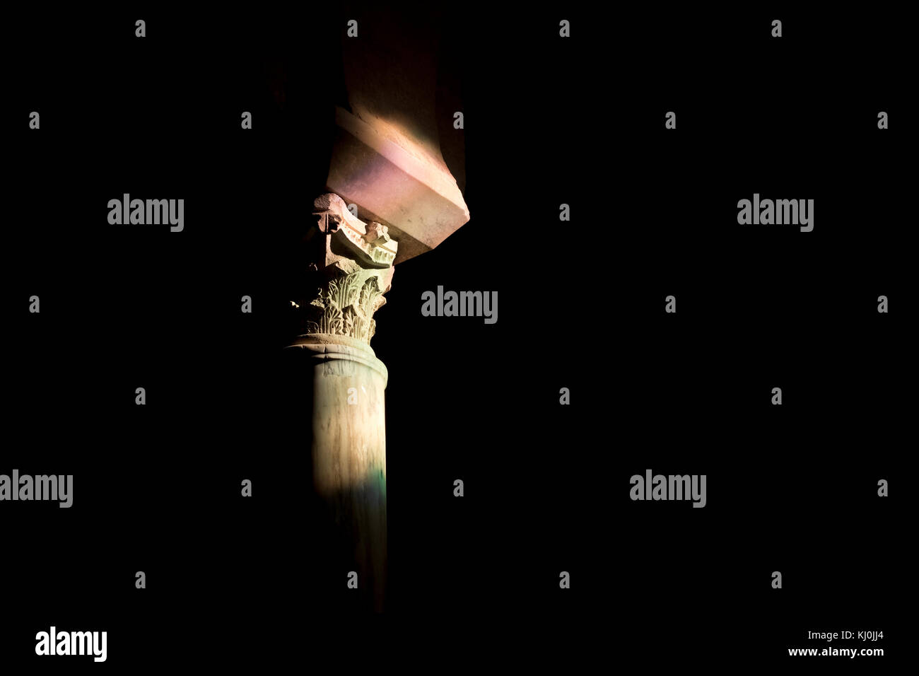 Rayo de luz de la capital de una columna de la Mezquita de Córdoba (Andalucía). Foto de stock