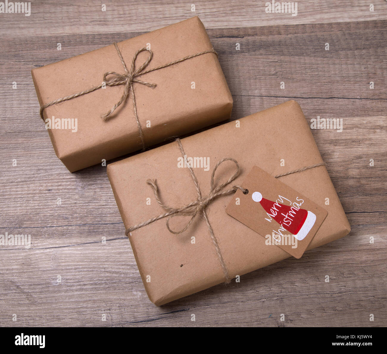 Navidad o año nuevo cajas de regalos envueltos en papel kraft con etiqueta  del regalo en blanco sobre fondo de madera vieja Fotografía de stock - Alamy