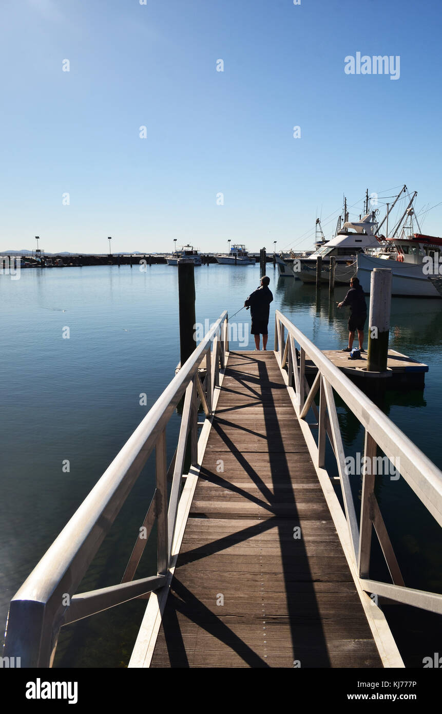 Nelson Bay, la gente pesca desde el muelle de la marina de la bahía Nelson NSW, Australia Foto de stock