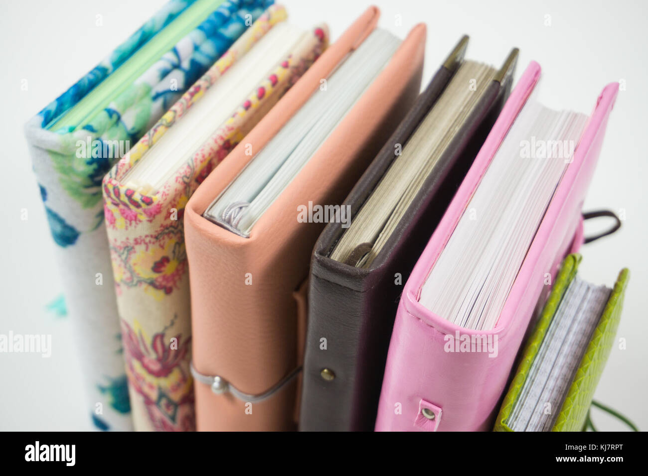 Cuadernos decorados a mano y planificadores de diferentes colores sobre  fondo blanco Fotografía de stock - Alamy