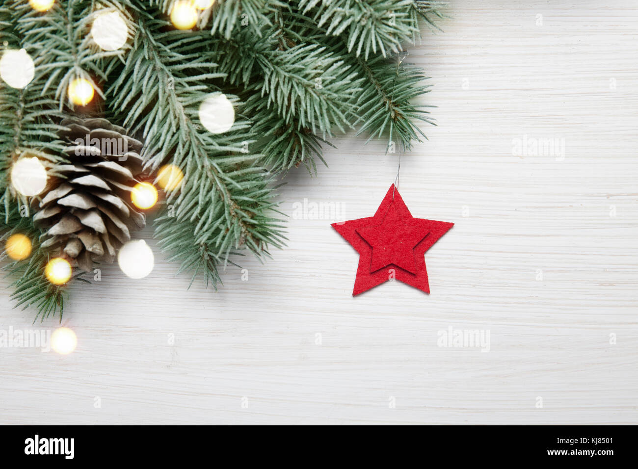 Christmas background. abeto blanco sobre fondo de madera con luces y estrella roja Foto de stock