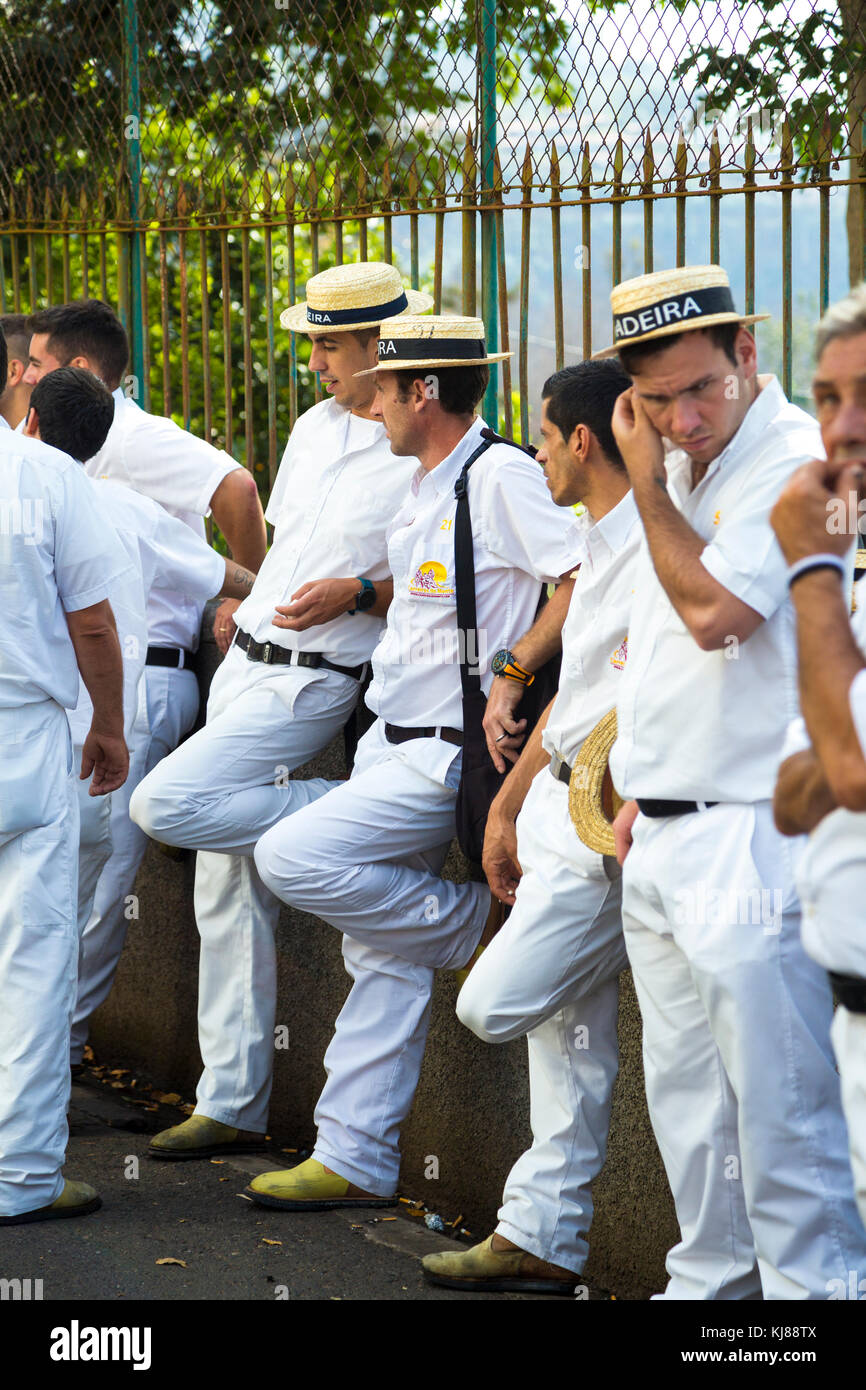 Toboggan controladores en ropa blanca y sombreros esperando el toboggan trineos para llegar a Monte, Madeira, Portugal Foto de stock