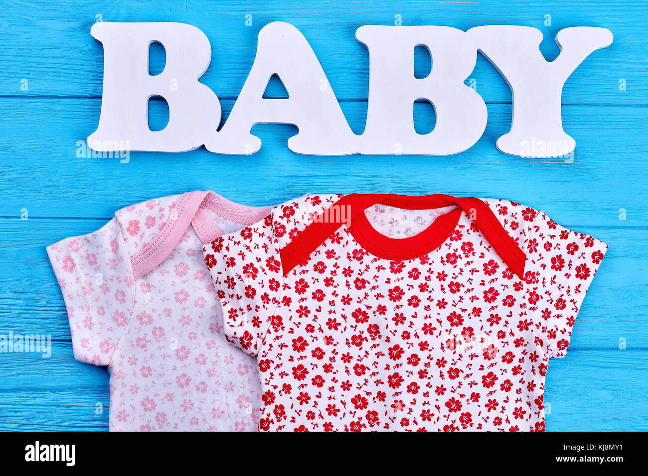 Conjunto de telas de bebé niña vestido. nuevas prendas de algodón para bebé  recién nacido, azul de fondo de madera natural. Compre ropa de bebé  Fotografía de stock - Alamy