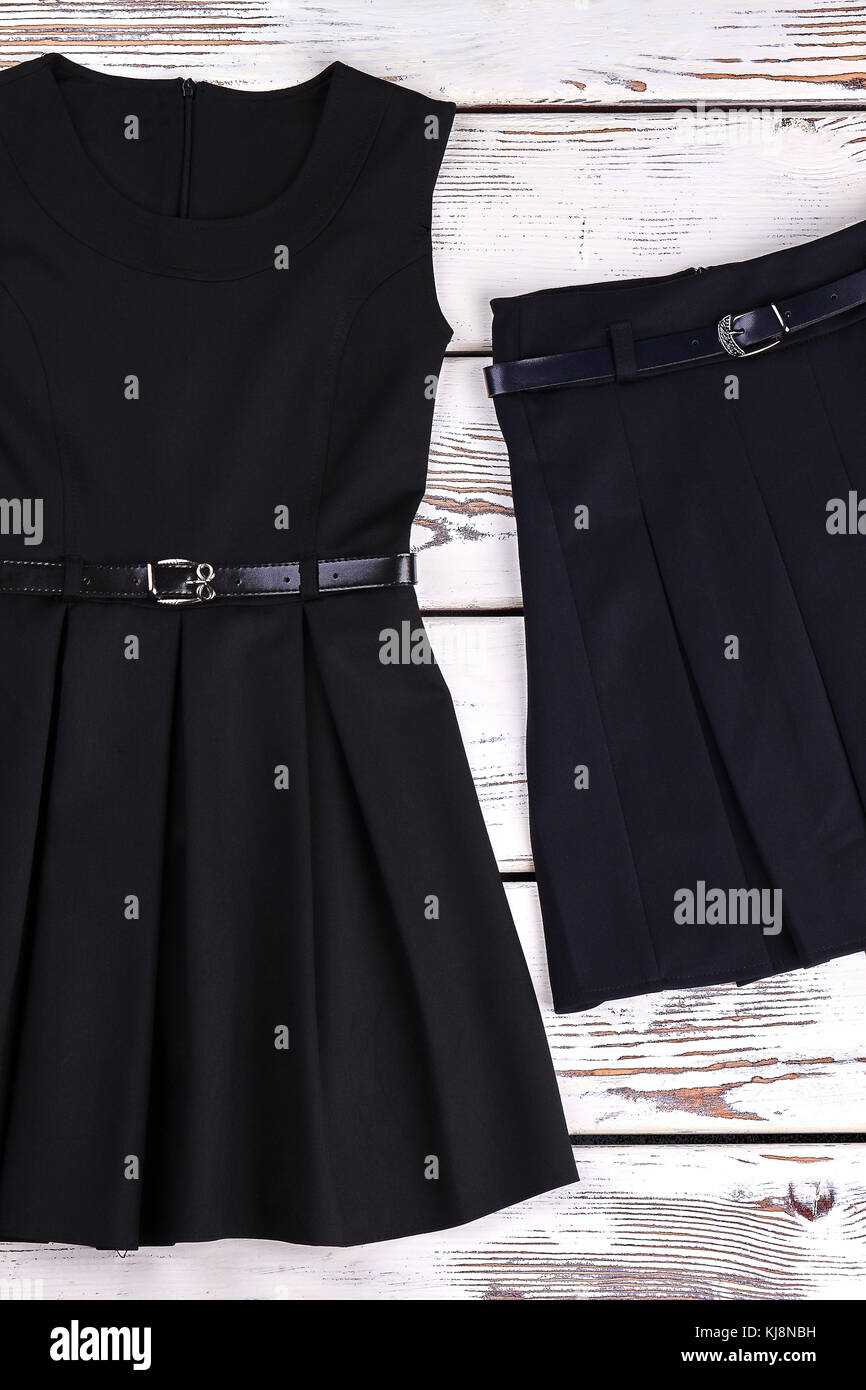Vestido negro con cinturón y falda. niña de la escuela clásico vestido negro  y falda plisada sobre fondo de madera vieja, vista superior Fotografía de  stock - Alamy