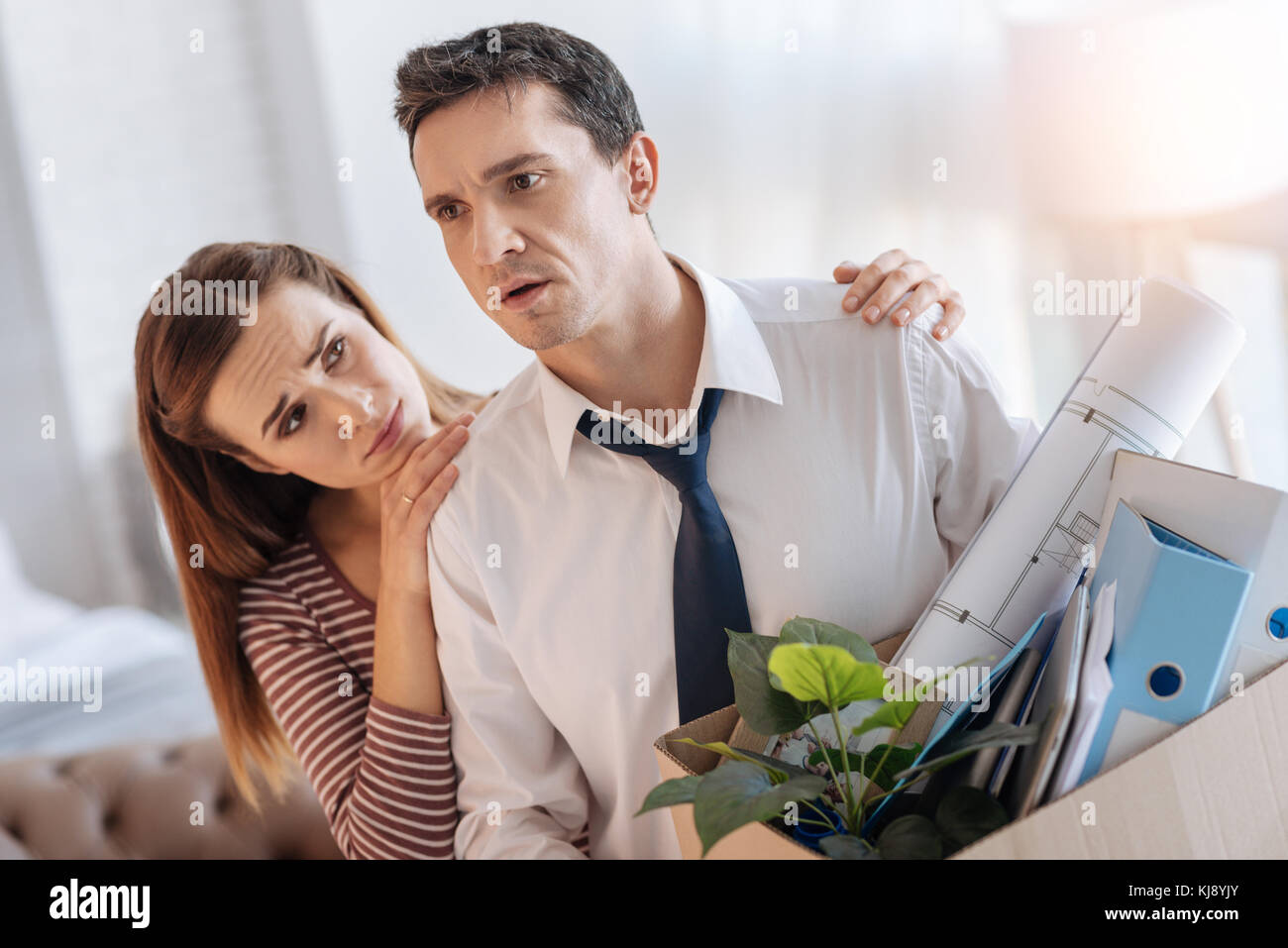 Amante esposa joven mirando su malestar desempleado marido Foto de stock