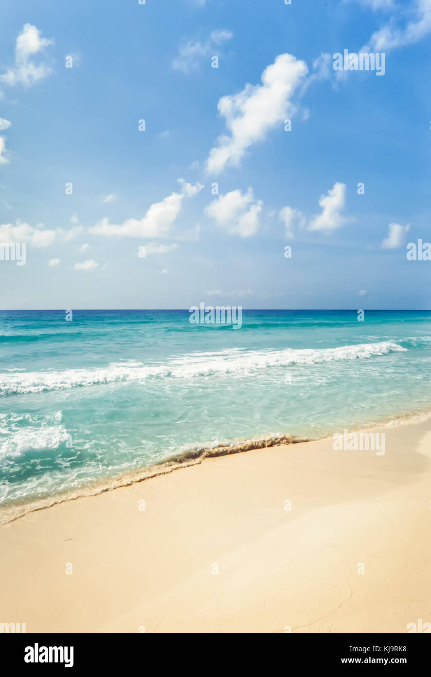 Tropical playa de arena dorada y aguas turquesas bajo un cielo azul en Cancún, México. Foto de stock