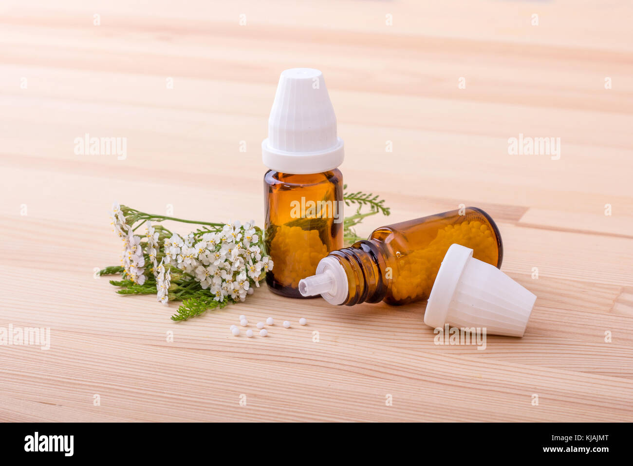 Remedio Homeopático con flores de milenrama con un fondo de madera Foto de stock