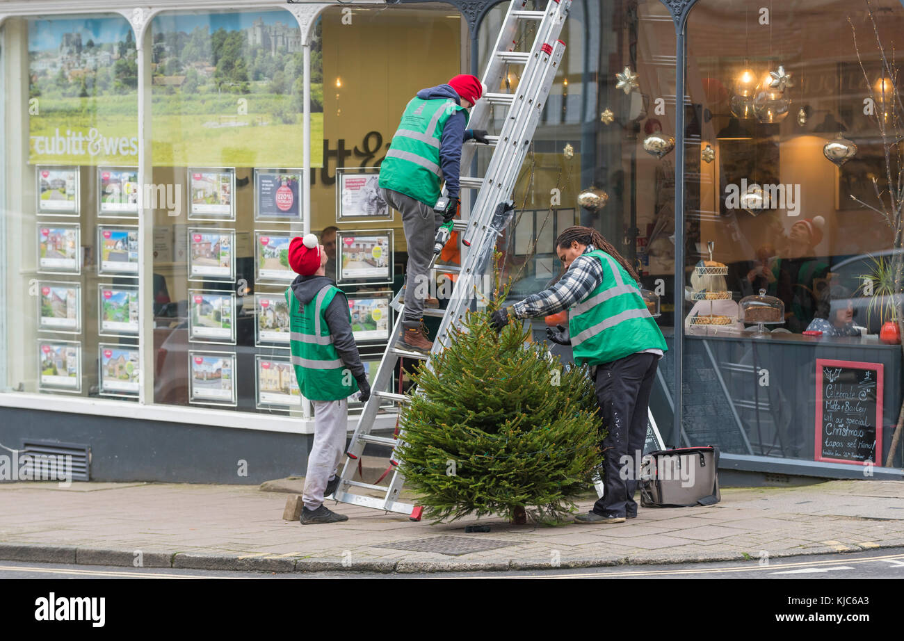 Personas vestidas con sombreros de Navidad poniendo un árbol de Navidad en  Arundel, West Sussex, Inglaterra, Reino Unido Fotografía de stock - Alamy