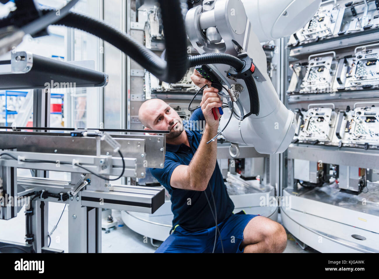 Hombre trabajando en robot industrial en la moderna fábrica Fotografía de  stock - Alamy