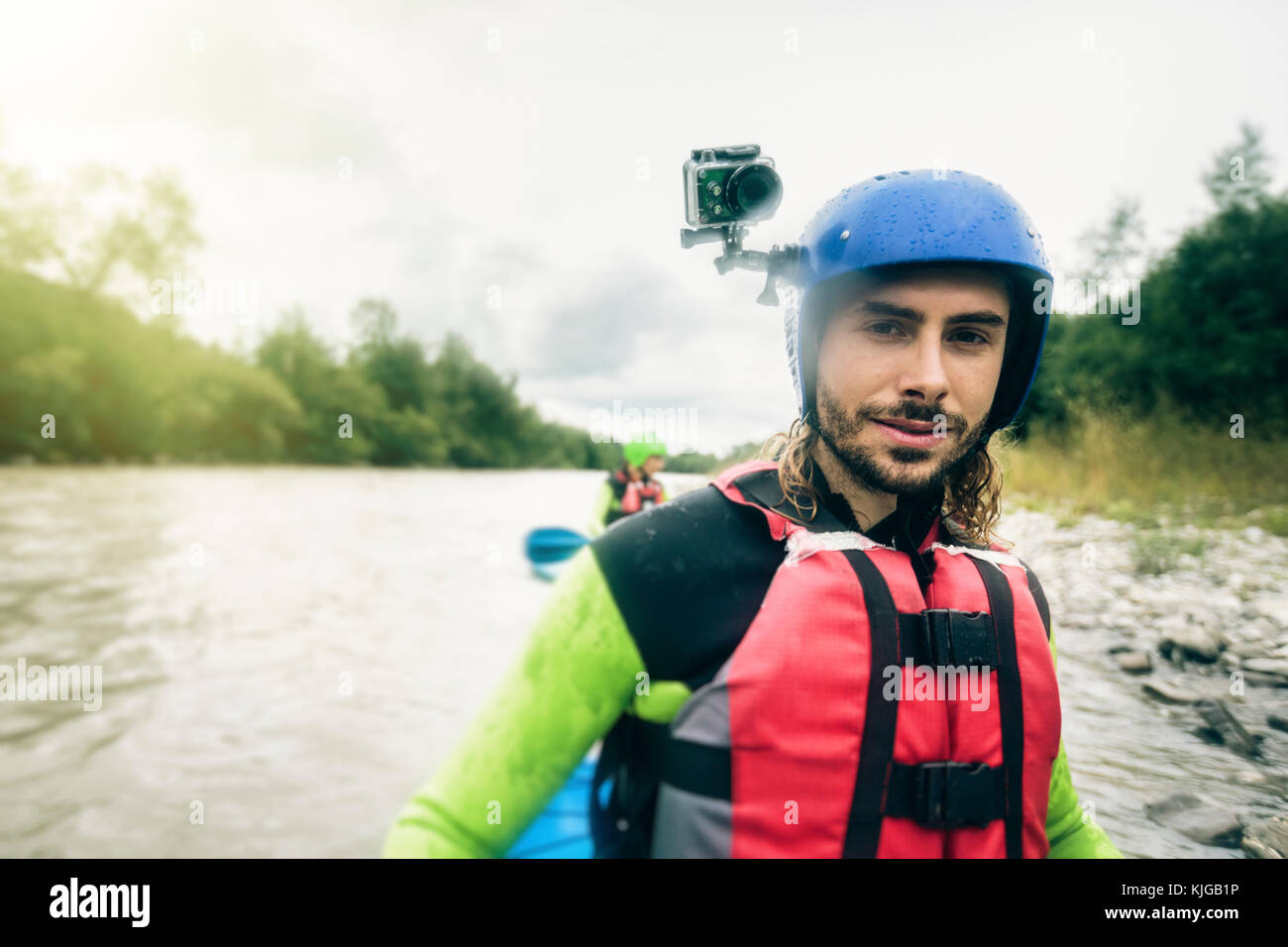 Alemania, Baviera, Allgaeu, portait de seguros joven con acción cam piragüismo en el río Iller Foto de stock