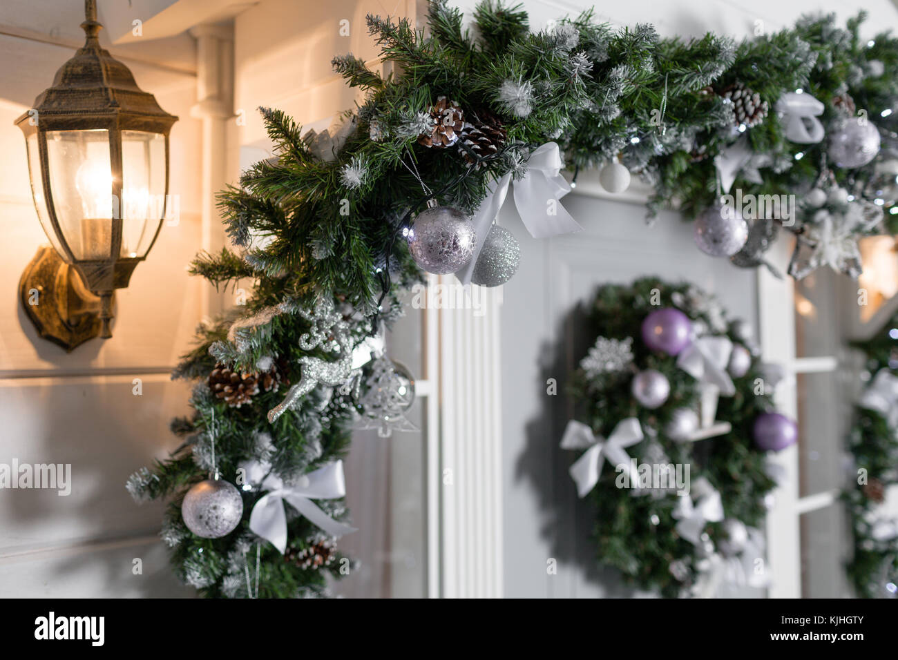 Entrada decorada casa de vacaciones. La decoración de Navidad. guirnalda de  ramas de abeto y las luces en la barandilla Fotografía de stock - Alamy