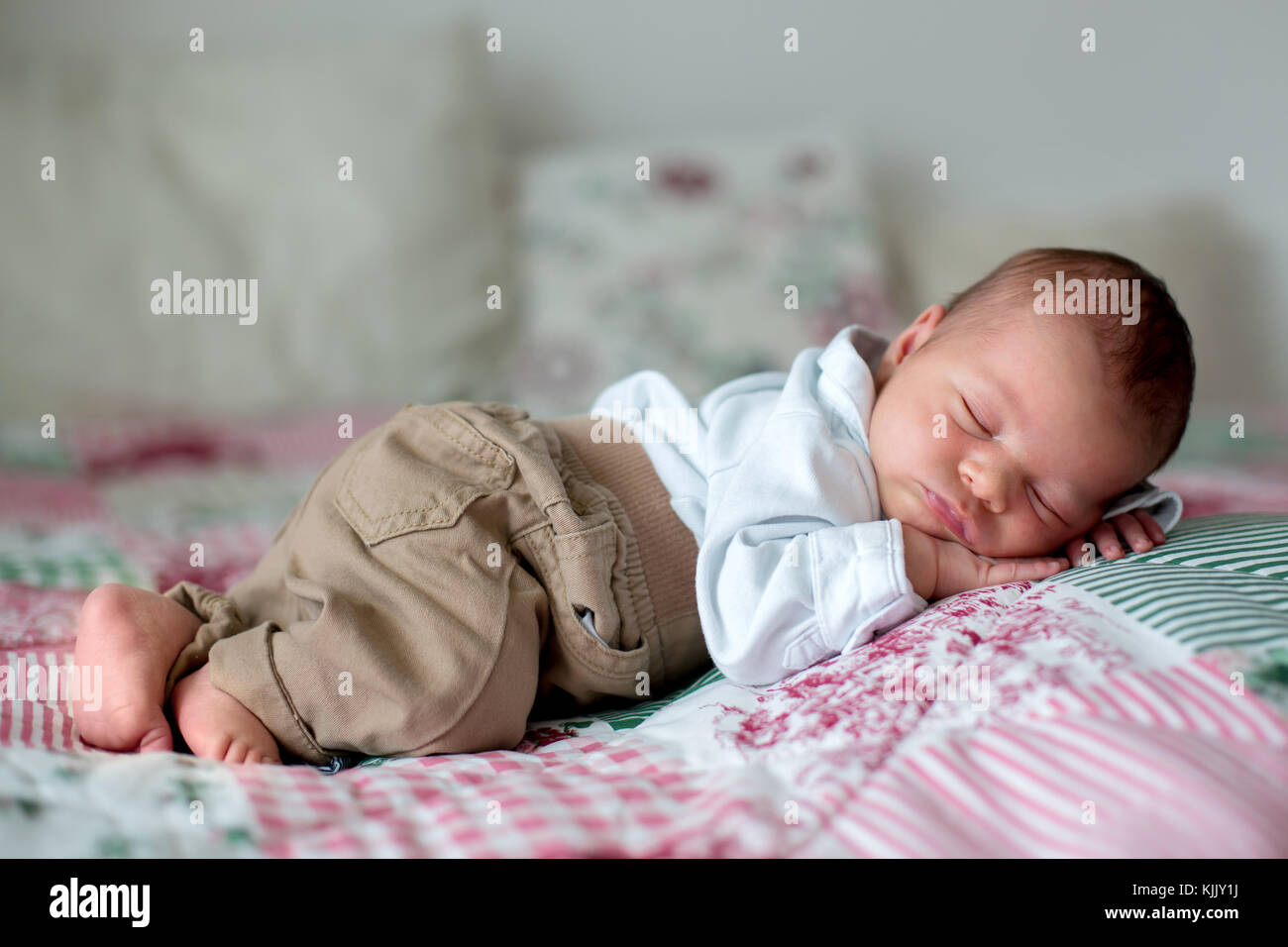 unir Peligro Interminable Pequeño y hermoso bebé recién nacido varón, vestido como poco señores,  dormir en la cama, lindo juguete junto a él Fotografía de stock - Alamy