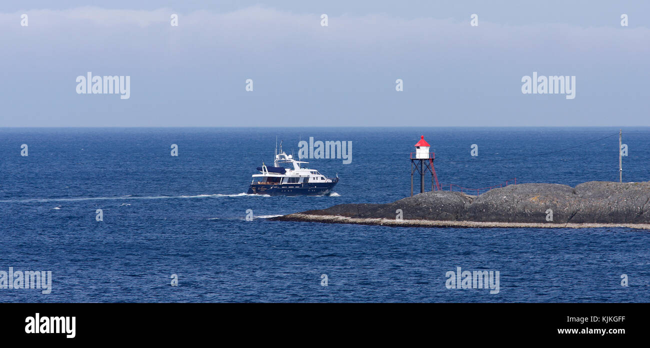Haugesund, Noruega, el 04 de julio, 2010. vista de un crucero azul y blanco, yate pasa una baliza. uso editorial. Foto de stock