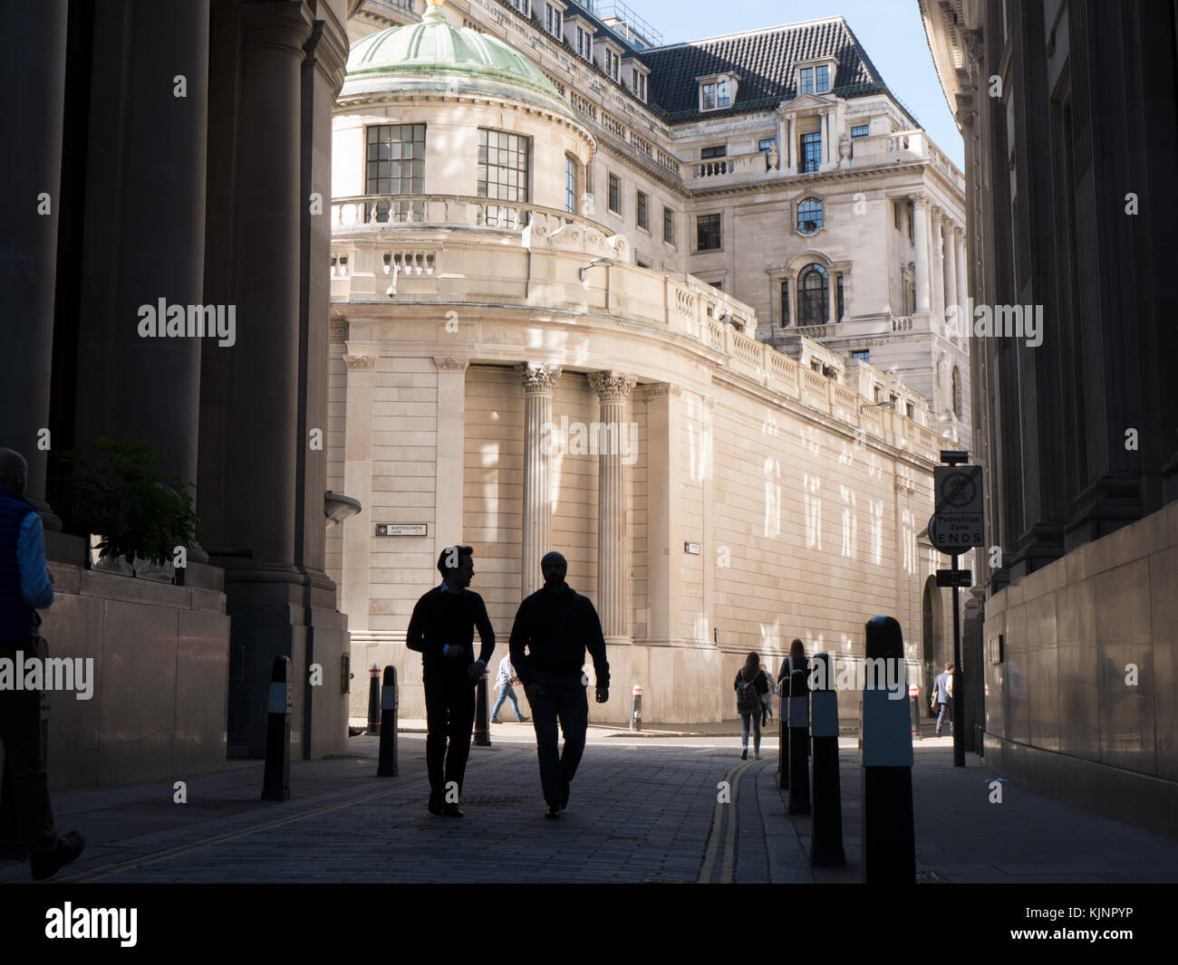 Banco de Inglaterra con trabajadores de la ciudad en el primer plano en sombra, visto desde la calle Throgmorton Foto de stock
