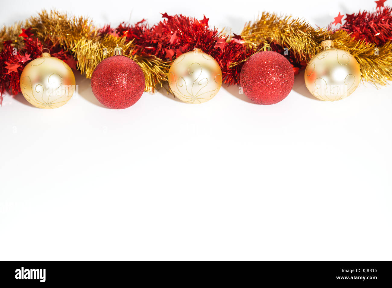 Decoraciones de navidad de color dorado y rojo sobre un fondo blanco -  bolas y guirnaldas Fotografía de stock - Alamy