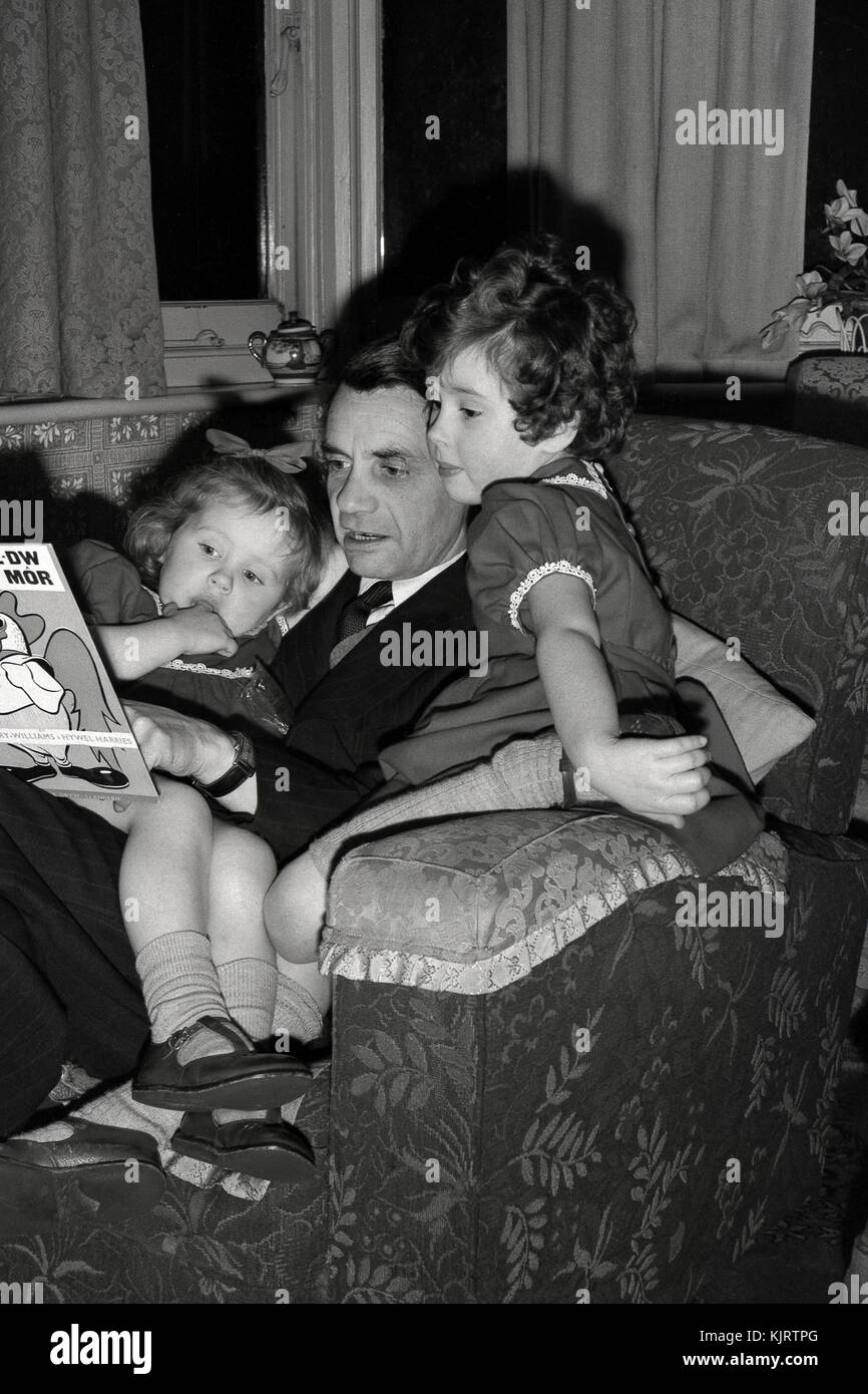Padre leyendo un cuento a sus hijas Foto de stock