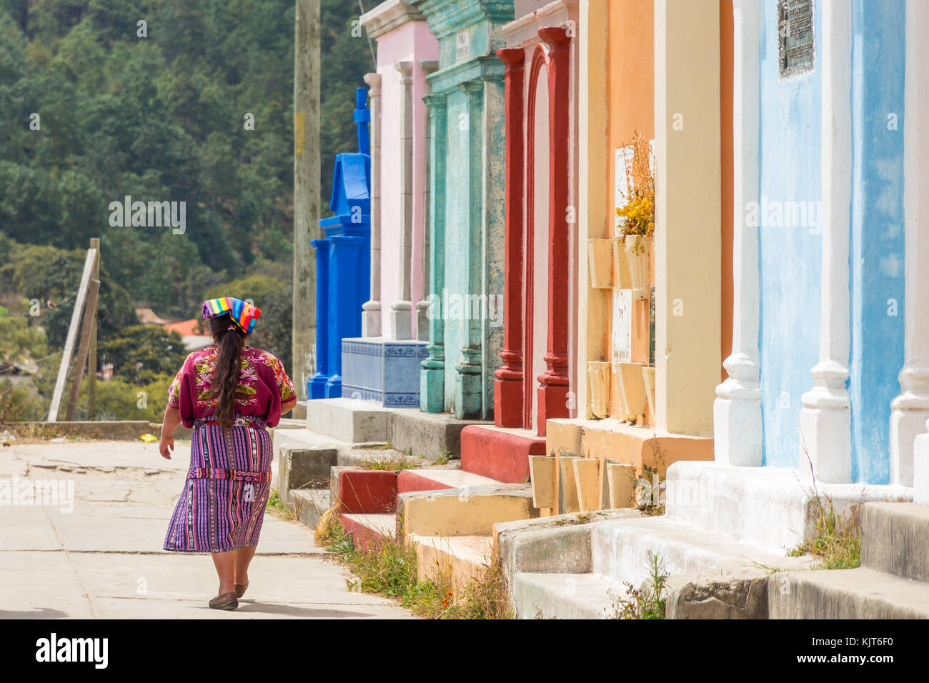 Mujer maya pasando por coloridas tumbas en el cementerio | Chichicastenango | Guatemala Foto de stock